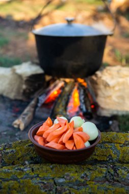 Açık ateşte hazırlanmış balık çorbası. Çaydanlıkta açık ateşte balık çorbası pişirmek. Turizm ve balıkçılıkta yemek pişirmek