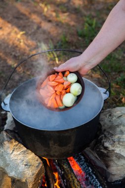 Açık ateşte hazırlanmış balık çorbası. Çaydanlıkta açık ateşte balık çorbası pişirmek. Turizm ve balıkçılıkta yemek pişirmek