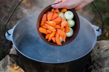 Açık ateşte hazırlanmış balık çorbası. Çaydanlıkta açık ateşte balık çorbası pişirmek. Turizm ve balıkçılıkta yemek pişirmek