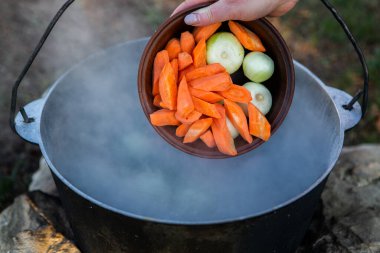 Açık ateşte hazırlanmış balık çorbası. Çaydanlıkta açık ateşte balık çorbası pişirmek. Turizm ve balıkçılıkta yemek pişirmek