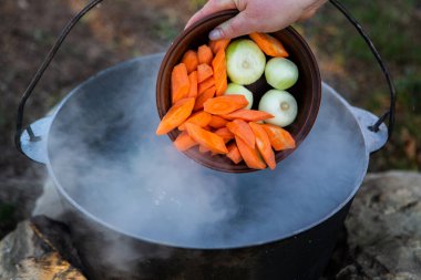 Açık ateşte hazırlanmış balık çorbası. Çaydanlıkta açık ateşte balık çorbası pişirmek. Turizm ve balıkçılıkta yemek pişirmek