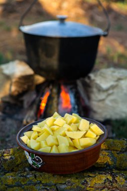 Açık ateşte hazırlanmış balık çorbası. Çaydanlıkta açık ateşte balık çorbası pişirmek. Turizm ve balıkçılıkta yemek pişirmek