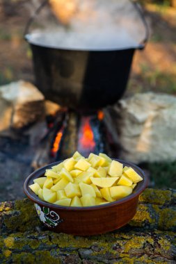 Açık ateşte hazırlanmış balık çorbası. Çaydanlıkta açık ateşte balık çorbası pişirmek. Turizm ve balıkçılıkta yemek pişirmek