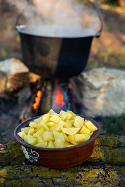 Açık ateşte hazırlanmış balık çorbası. Çaydanlıkta açık ateşte balık çorbası pişirmek. Turizm ve balıkçılıkta yemek pişirmek