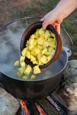 Açık ateşte hazırlanmış balık çorbası. Çaydanlıkta açık ateşte balık çorbası pişirmek. Turizm ve balıkçılıkta yemek pişirmek