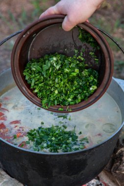 Açık ateşte hazırlanmış balık çorbası. Çaydanlıkta açık ateşte balık çorbası pişirmek. Turizm ve balıkçılıkta yemek pişirmek