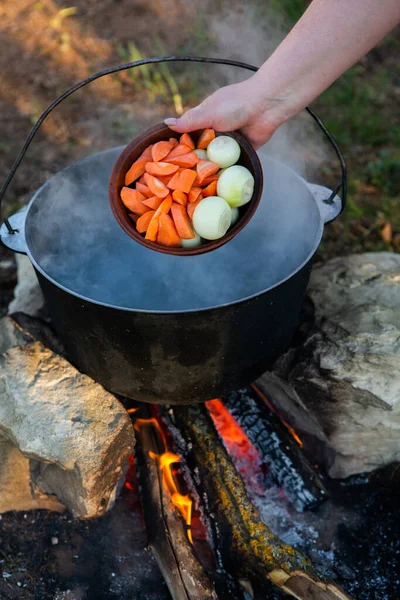 Açık ateşte hazırlanmış balık çorbası. Çaydanlıkta açık ateşte balık çorbası pişirmek. Turizm ve balıkçılıkta yemek pişirmek
