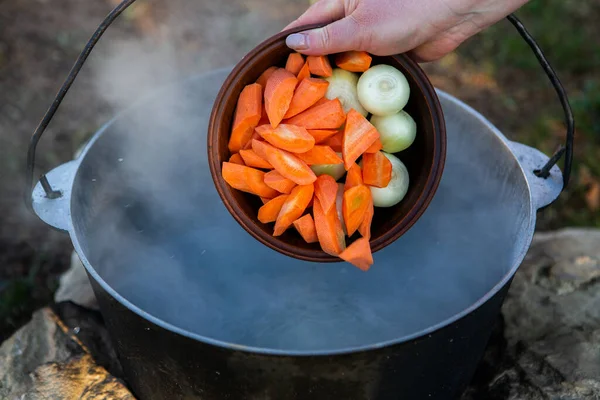 Açık ateşte hazırlanmış balık çorbası. Çaydanlıkta açık ateşte balık çorbası pişirmek. Turizm ve balıkçılıkta yemek pişirmek