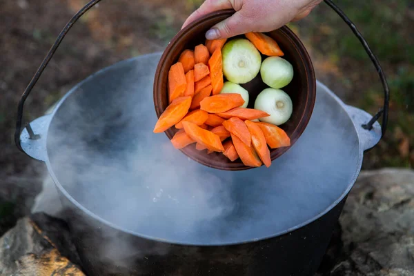 Açık ateşte hazırlanmış balık çorbası. Çaydanlıkta açık ateşte balık çorbası pişirmek. Turizm ve balıkçılıkta yemek pişirmek