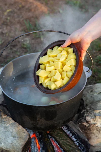 Açık ateşte hazırlanmış balık çorbası. Çaydanlıkta açık ateşte balık çorbası pişirmek. Turizm ve balıkçılıkta yemek pişirmek