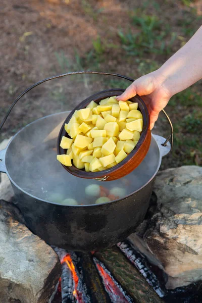 Açık ateşte hazırlanmış balık çorbası. Çaydanlıkta açık ateşte balık çorbası pişirmek. Turizm ve balıkçılıkta yemek pişirmek