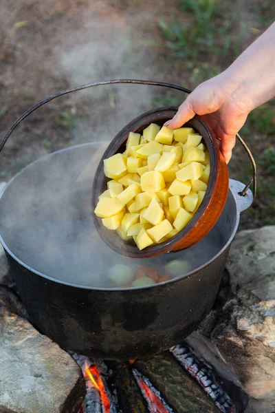Açık ateşte hazırlanmış balık çorbası. Çaydanlıkta açık ateşte balık çorbası pişirmek. Turizm ve balıkçılıkta yemek pişirmek