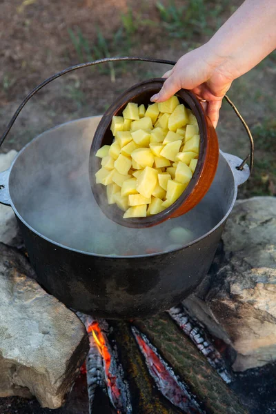 Açık ateşte hazırlanmış balık çorbası. Çaydanlıkta açık ateşte balık çorbası pişirmek. Turizm ve balıkçılıkta yemek pişirmek