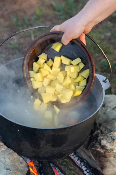 Açık ateşte hazırlanmış balık çorbası. Çaydanlıkta açık ateşte balık çorbası pişirmek. Turizm ve balıkçılıkta yemek pişirmek