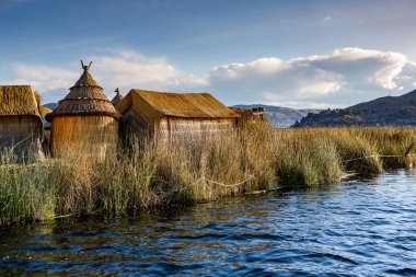 Peru, Titicaca Gölü 'ndeki yüzen köy Uros. Titicaca Gölü, Güney Amerika 'daki en büyük göl ve dünyanın en yüksek seyir edilebilir gölüdür..