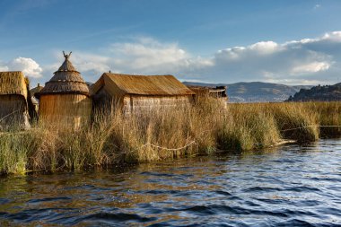 Peru, Titicaca Gölü 'ndeki yüzen köy Uros. Titicaca Gölü, Güney Amerika 'daki en büyük göl ve dünyanın en yüksek seyir edilebilir gölüdür..