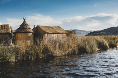 Peru, Titicaca Gölü 'ndeki yüzen köy Uros. Titicaca Gölü, Güney Amerika 'daki en büyük göl ve dünyanın en yüksek seyir edilebilir gölüdür..