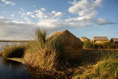 Peru, Titicaca Gölü 'ndeki yüzen köy Uros. Titicaca Gölü, Güney Amerika 'daki en büyük göl ve dünyanın en yüksek seyir edilebilir gölüdür..