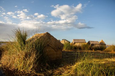 Peru, Titicaca Gölü 'ndeki yüzen köy Uros. Titicaca Gölü, Güney Amerika 'daki en büyük göl ve dünyanın en yüksek seyir edilebilir gölüdür..