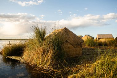 Peru, Titicaca Gölü 'ndeki yüzen köy Uros. Titicaca Gölü, Güney Amerika 'daki en büyük göl ve dünyanın en yüksek seyir edilebilir gölüdür..