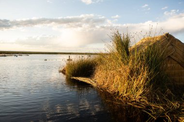 Peru, Titicaca Gölü 'ndeki yüzen köy Uros. Titicaca Gölü, Güney Amerika 'daki en büyük göl ve dünyanın en yüksek seyir edilebilir gölüdür..