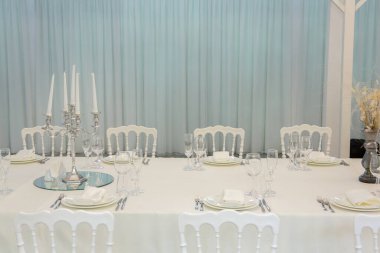 Empty banquet hall ready to receive guests on the summer terrace. white festive table