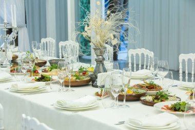 Empty banquet hall ready to receive guests on the summer terrace. white festive table
