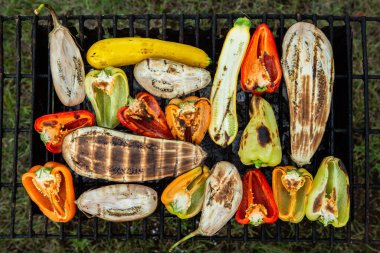 Fresh vegetables prepared on the grill outside. Tomatoes, sweet peppers, eggplant cooked outside.