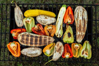 Fresh vegetables prepared on the grill outside. Tomatoes, sweet peppers, eggplant cooked outside.