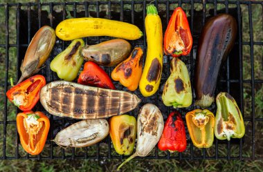 Fresh vegetables prepared on the grill outside. Tomatoes, sweet peppers, eggplant cooked outside.