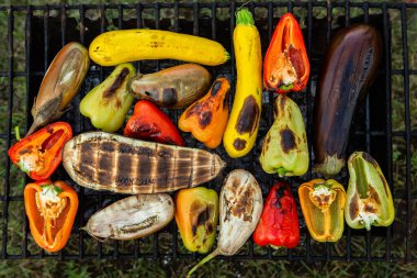 Fresh vegetables prepared on the grill outside. Tomatoes, sweet peppers, eggplant cooked outside.