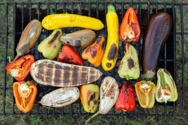 Fresh vegetables prepared on the grill outside. Tomatoes, sweet peppers, eggplant cooked outside.