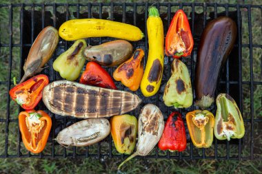 Fresh vegetables prepared on the grill outside. Tomatoes, sweet peppers, eggplant cooked outside.
