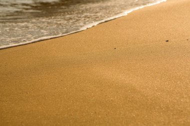 Girit adasının kıyısında altın kumu olan bir arka plan. Metin için kum ve berrak deniz suyuyla soyut yüzey.