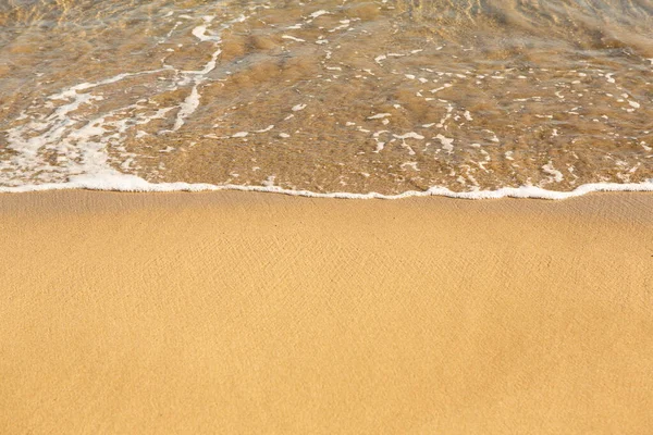 Girit adasının kıyısında altın kumu olan bir arka plan. Metin için kum ve berrak deniz suyuyla soyut yüzey.