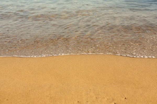 クレタ島の海岸に黄金の砂と背景 テキストのための砂と澄んだ海の水の抽象的な表面 ストック画像