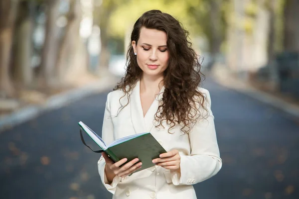 Portrait of a business woman with a notebook in her hand.  Smartly dressed girl outside. Successful white european woman