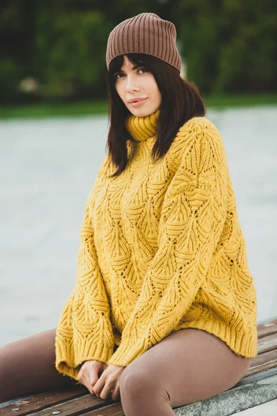 美しいヨーロッパのブルネットは黄色のウールのセーターと帽子を外で着ていました 涼しい天気の中で太いスタイリッシュな秋の服を身に着けている美しい女の子 — ストック写真