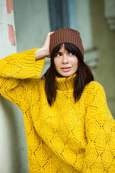 美しいヨーロッパのブルネットは黄色のウールのセーターと帽子を外で着ていました 涼しい天気の中で太いスタイリッシュな秋の服を身に着けている美しい女の子 — ストック写真