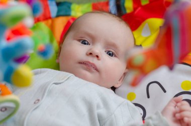 Bebek sallanan çıngıraklara bakar, yakın plan.