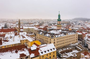 58 metre yüksekliğindeki ikonik ateş kulesi ve şehrin merkezindeki Sopron belediye binası havadan izleniyor. Karlı çatıları olan kış şehirleri.