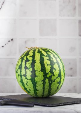 Taze olgun karpuz, arka planda bir tahtada. Sağlıklı gıda konsepti. Vejetaryen yemeği. Dikey konum. Boşluğu kopyala.