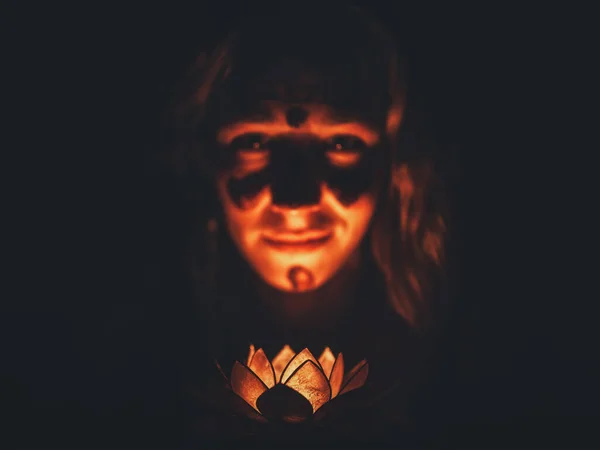 Mujer meditando con vela de loto en la mano. La mujer está pintada en su cara con cacao, ceremonia de cacao. — Foto de Stock