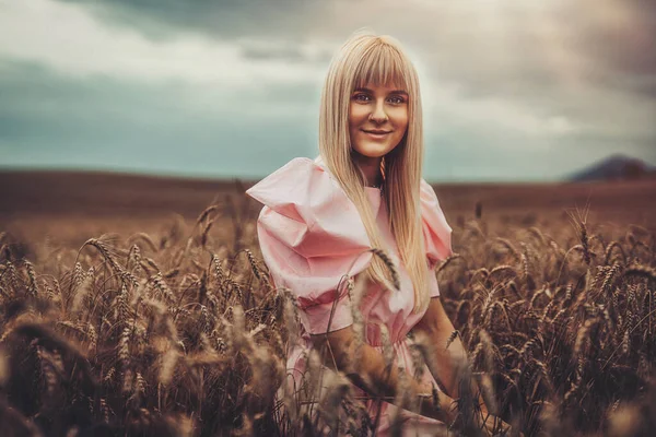 Vacker kvinna i prydnadskläder på ett vetefält. — Stockfoto