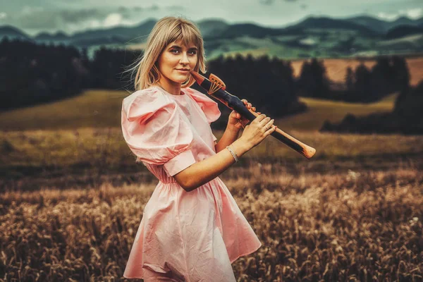 Chica jugando en chamán flauta en la naturaleza. — Foto de Stock