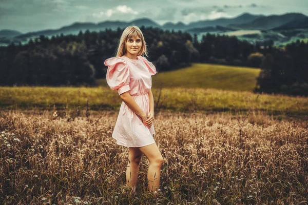 Beautiful woman in ornamental clothing in a wheat field. — Stock Photo, Image