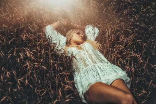 Hermosa mujer en ropa ornamental en un campo de trigo. — Foto de Stock