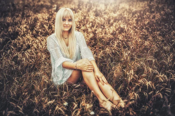 Mooie vrouw in sierlijke kleding in een tarweveld. — Stockfoto