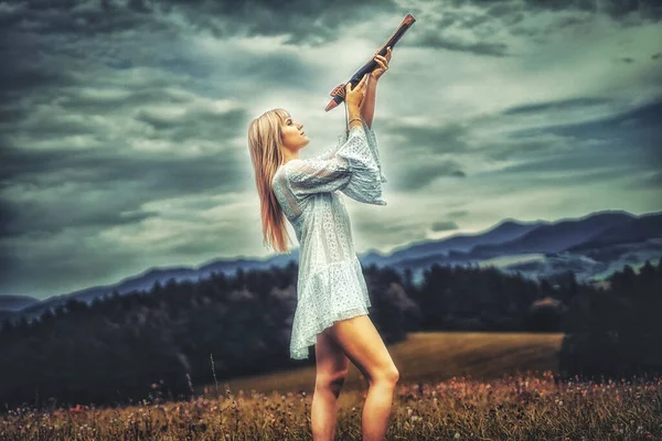 自然の中でシャーマンフルートを演奏している女の子は. — ストック写真