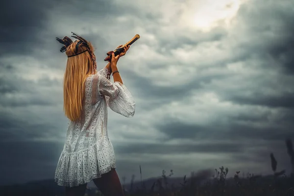 Piękna szamanka dziewczyna gra na flet szamana w przyrodzie. — Zdjęcie stockowe